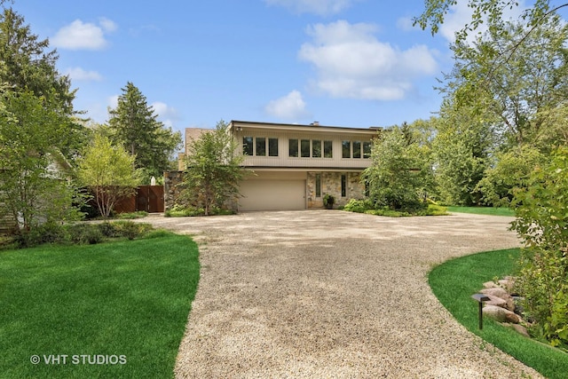view of front of house with an attached garage, driveway, and stone siding