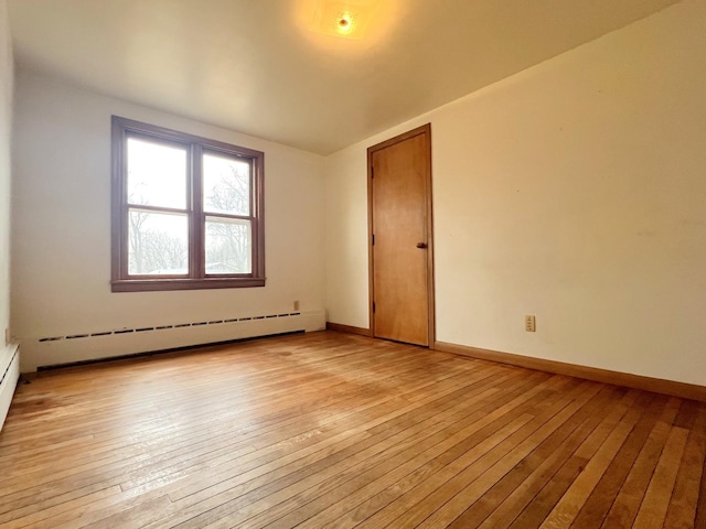 unfurnished room with light wood-type flooring, baseboards, and baseboard heating