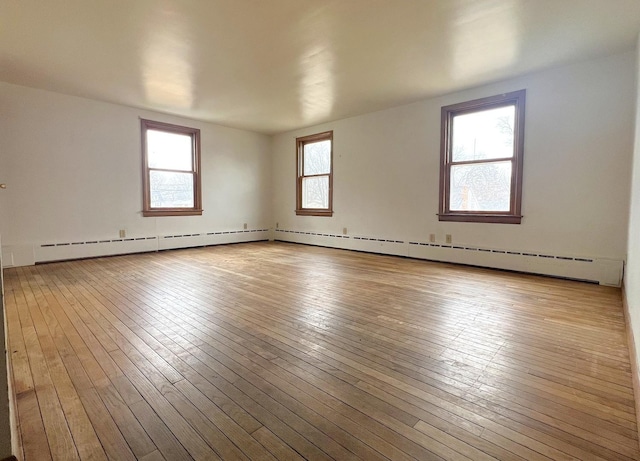 spare room featuring a healthy amount of sunlight and wood-type flooring