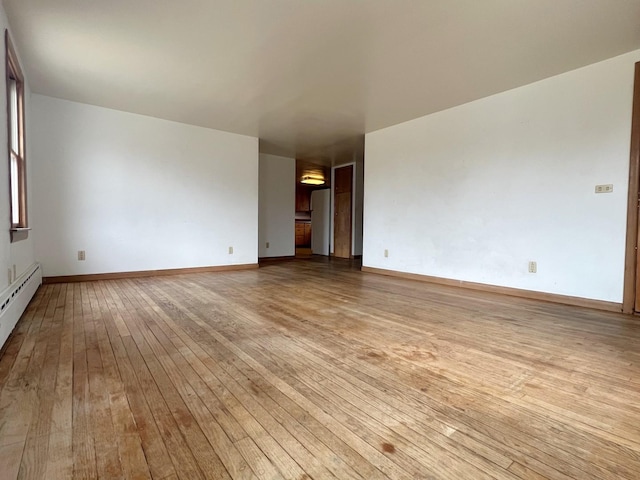 unfurnished room featuring baseboards and light wood-style floors