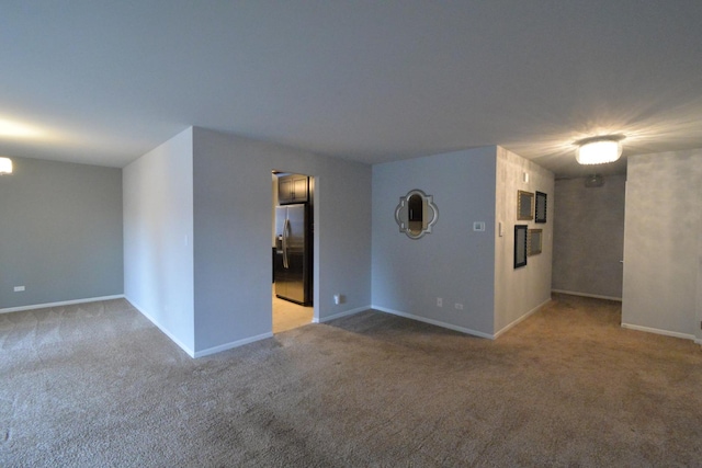 carpeted spare room with baseboards