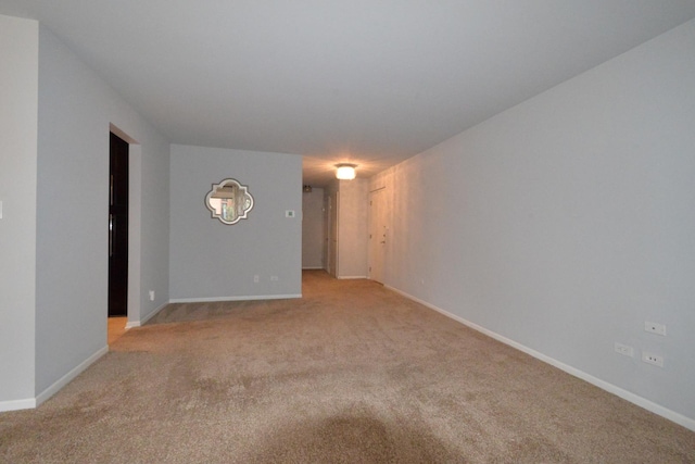 unfurnished room featuring baseboards and light carpet