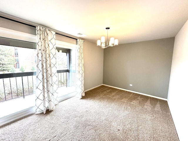 spare room featuring a notable chandelier, visible vents, baseboards, and carpet floors