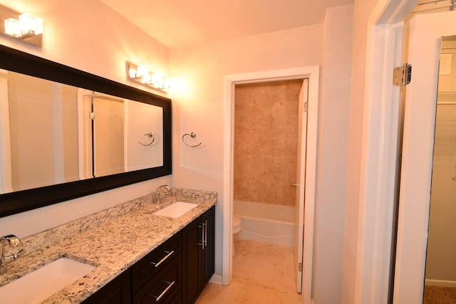 full bath featuring a sink, toilet, double vanity, and a washtub