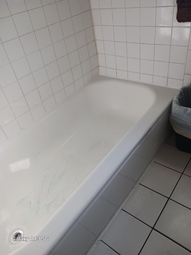 bathroom with tile patterned flooring and a washtub