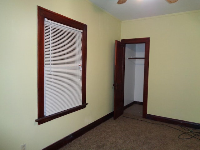 empty room with a ceiling fan, baseboards, carpet floors, and ornamental molding