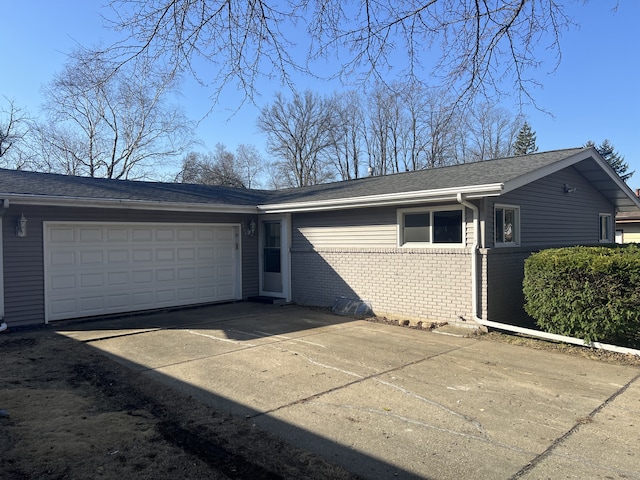 exterior space with brick siding, driveway, and a garage