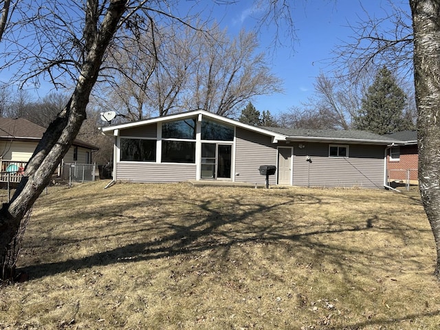 back of property with fence and a sunroom