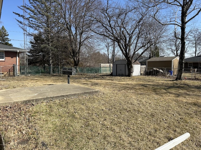 view of yard with a storage unit, an outbuilding, and fence