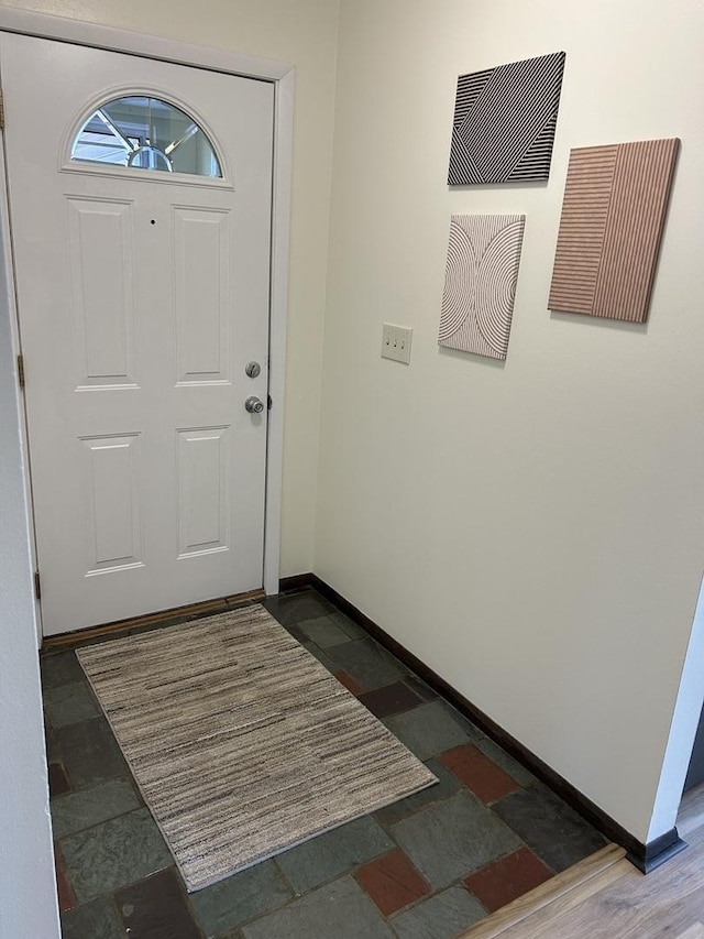 foyer featuring baseboards and stone tile flooring