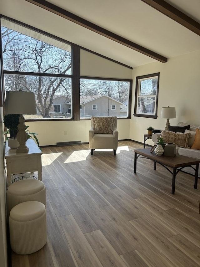 living area featuring lofted ceiling with beams, wood finished floors, and visible vents