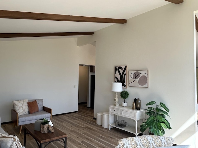 sitting room featuring lofted ceiling with beams and wood finished floors