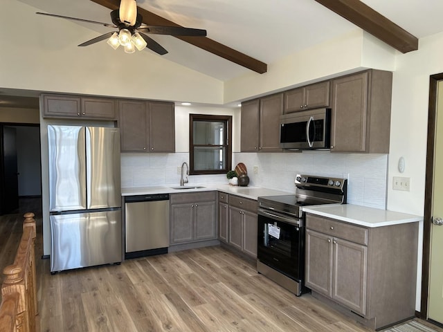 kitchen featuring a sink, light countertops, a ceiling fan, and stainless steel appliances