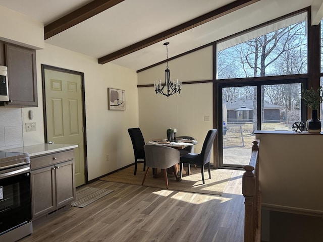 dining room featuring baseboards, a notable chandelier, wood finished floors, and vaulted ceiling with beams