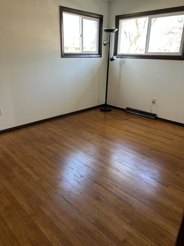 spare room with visible vents, wood finished floors, and baseboards