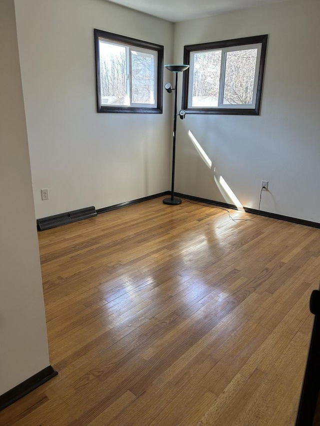 empty room with visible vents, baseboards, and wood finished floors