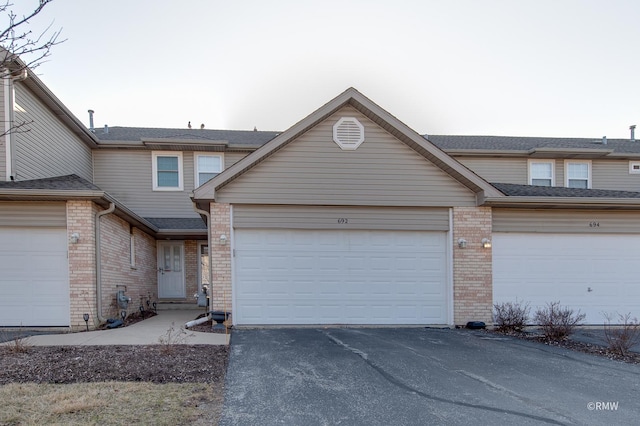 view of property with brick siding and driveway