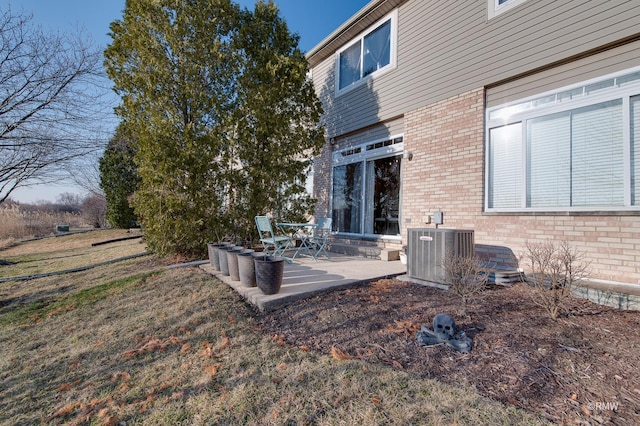 exterior space with a patio, brick siding, and central AC