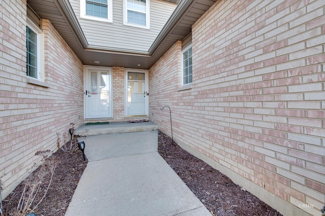 doorway to property featuring brick siding