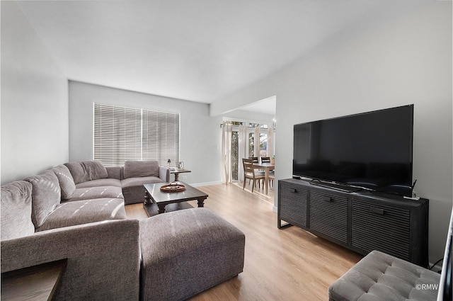 living room featuring baseboards and light wood-style flooring