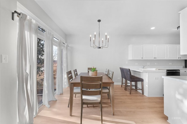 dining room featuring light wood finished floors and a chandelier