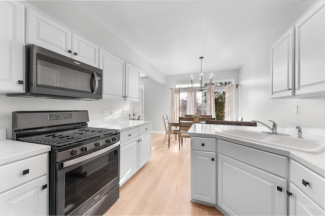 kitchen with white cabinetry, stainless steel range with gas cooktop, and a sink