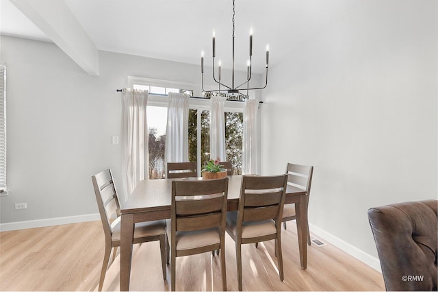 dining area featuring a chandelier, visible vents, light wood-style flooring, and baseboards