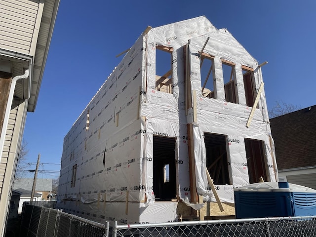 view of building exterior featuring cooling unit and fence