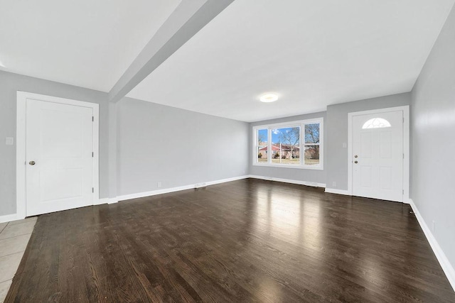 unfurnished living room with baseboards and wood finished floors