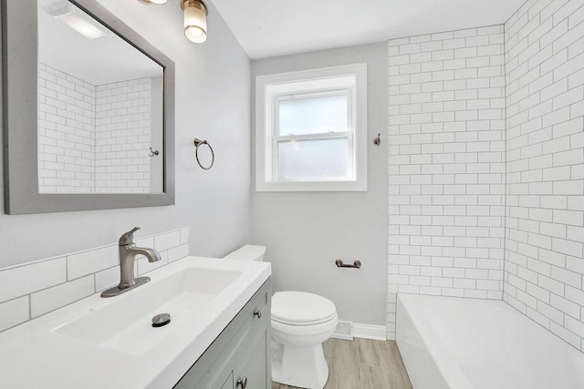 full bathroom featuring vanity, wood finished floors, baseboards, shower / bath combination, and toilet