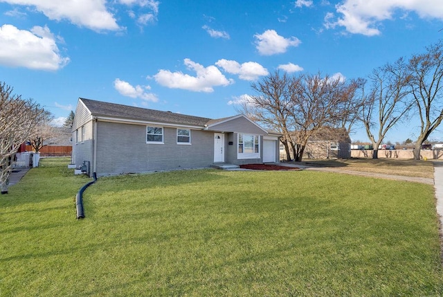 ranch-style home featuring a front lawn, an attached garage, brick siding, and driveway