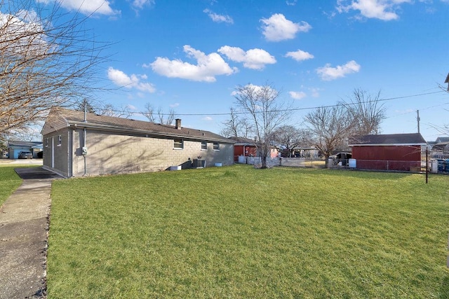 view of yard with fence and central AC