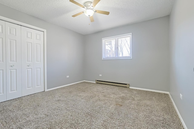 unfurnished bedroom with baseboards, a closet, a textured ceiling, carpet flooring, and baseboard heating