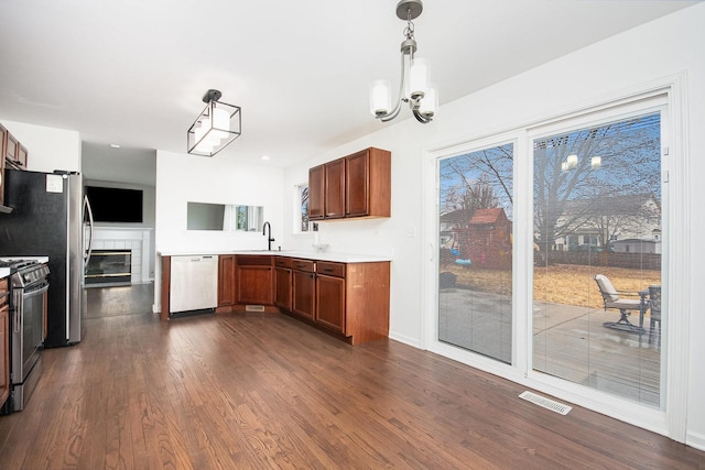 kitchen with dark wood-type flooring, visible vents, appliances with stainless steel finishes, and a sink