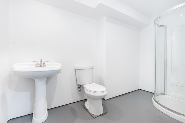 full bathroom featuring a stall shower, toilet, and finished concrete flooring