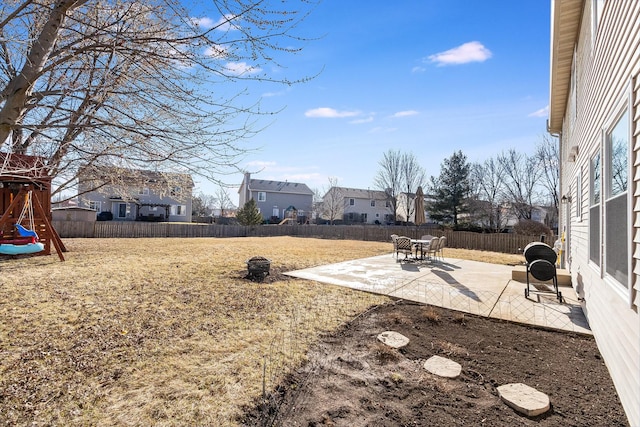 view of yard with a fenced backyard, a playground, and a patio