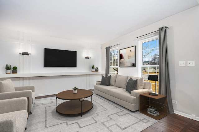 living area with baseboards and wood finished floors