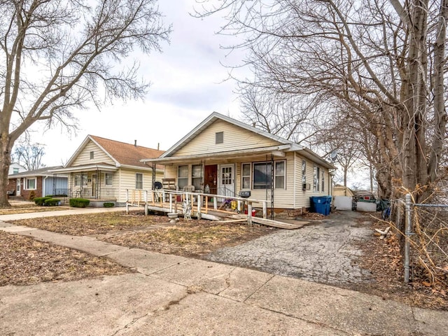 bungalow-style home with a porch and driveway