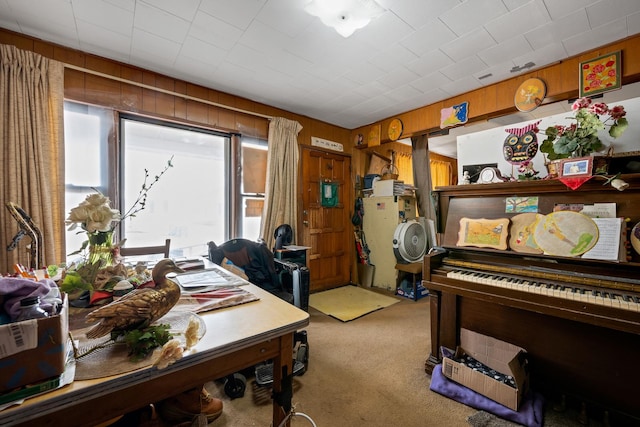 office area featuring light colored carpet and wood walls