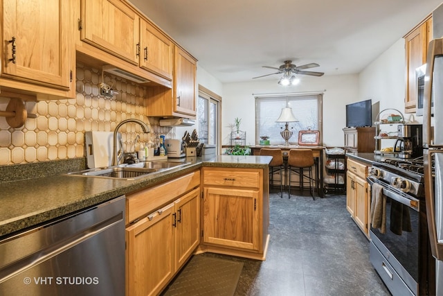 kitchen featuring a sink, dark countertops, appliances with stainless steel finishes, and ceiling fan