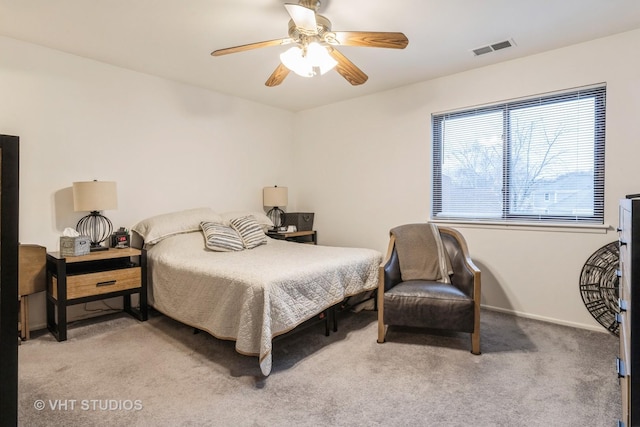 carpeted bedroom featuring a ceiling fan, visible vents, and baseboards