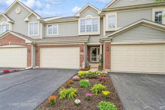 townhome / multi-family property featuring brick siding and driveway