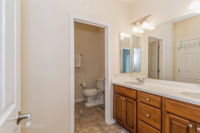 full bathroom featuring a sink, toilet, double vanity, and tile patterned flooring