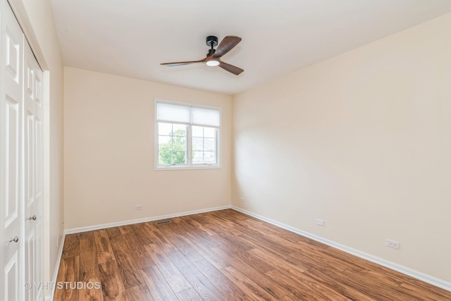 spare room featuring baseboards, ceiling fan, and wood finished floors