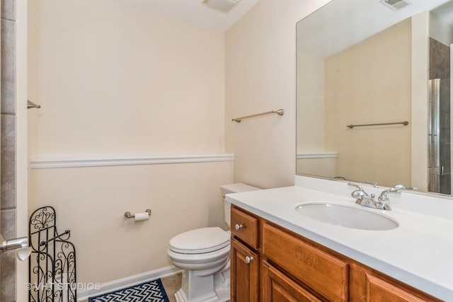 bathroom featuring visible vents, toilet, vanity, and baseboards