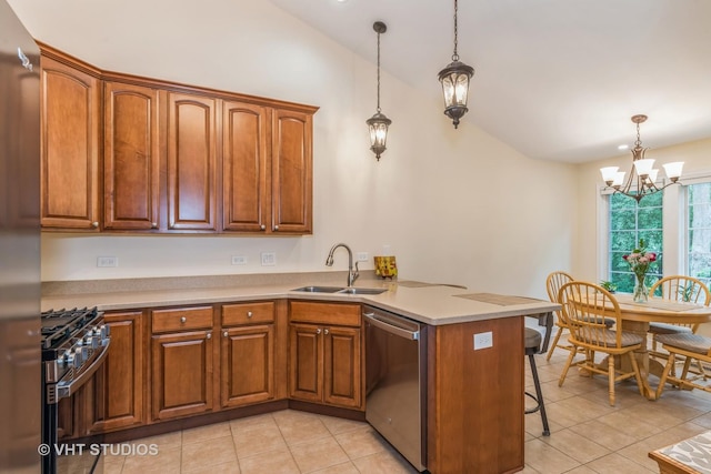 kitchen with a peninsula, a sink, vaulted ceiling, appliances with stainless steel finishes, and brown cabinets