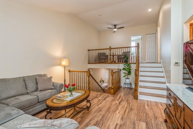 living area with baseboards, lofted ceiling, recessed lighting, ceiling fan, and light wood-style floors