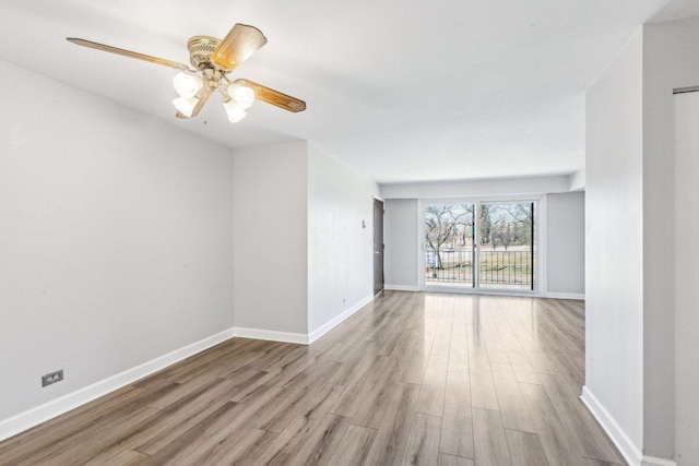 spare room with ceiling fan, baseboards, and wood finished floors