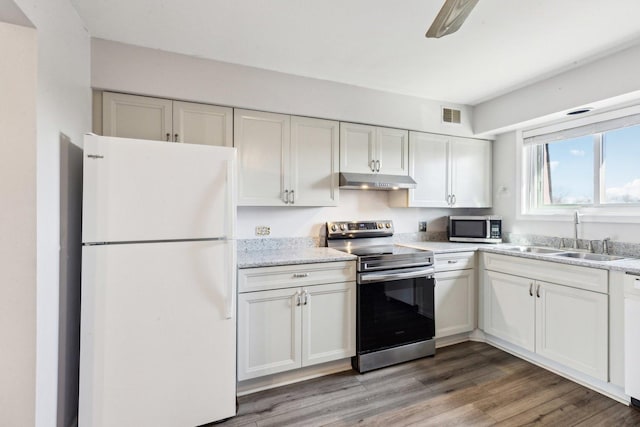 kitchen featuring visible vents, a sink, under cabinet range hood, white cabinetry, and appliances with stainless steel finishes