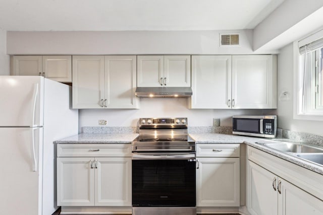 kitchen with under cabinet range hood, stainless steel appliances, visible vents, and white cabinetry